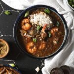 Three bowls of seafood gumbo with shrimp and crab from above