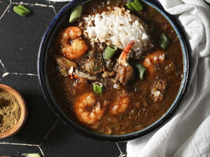 Three bowls of seafood gumbo with shrimp and crab from above