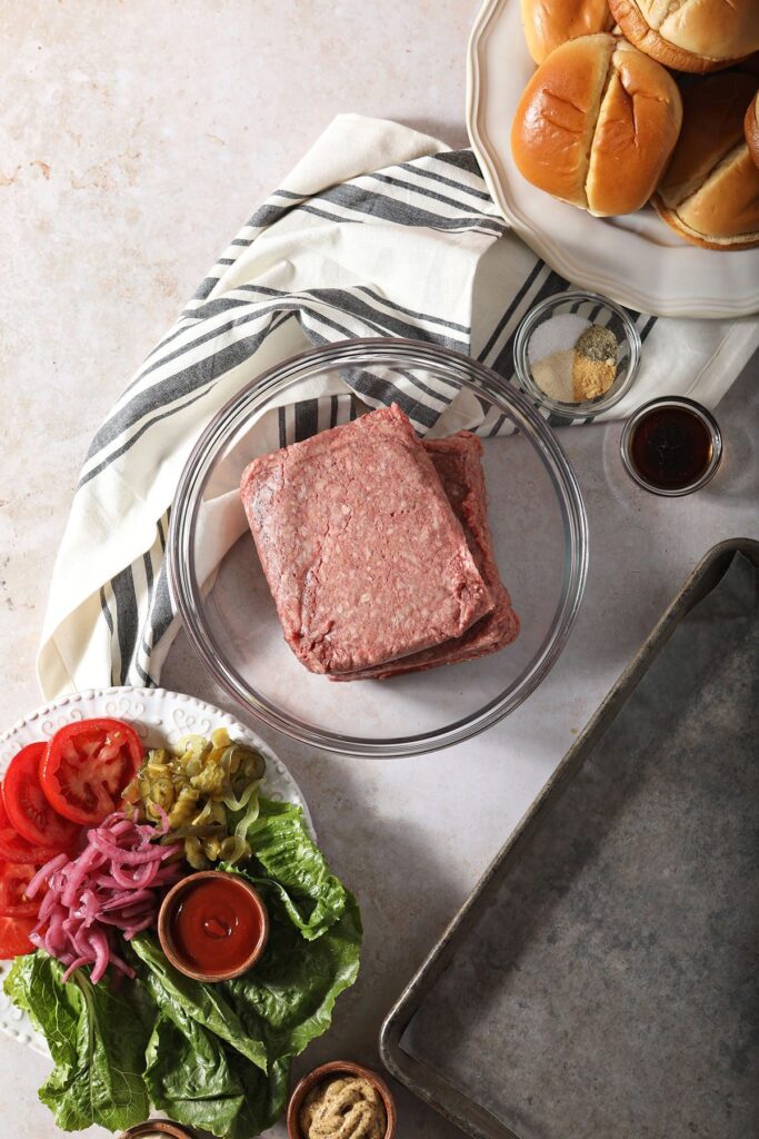 Burger ingredients in bowls on a table