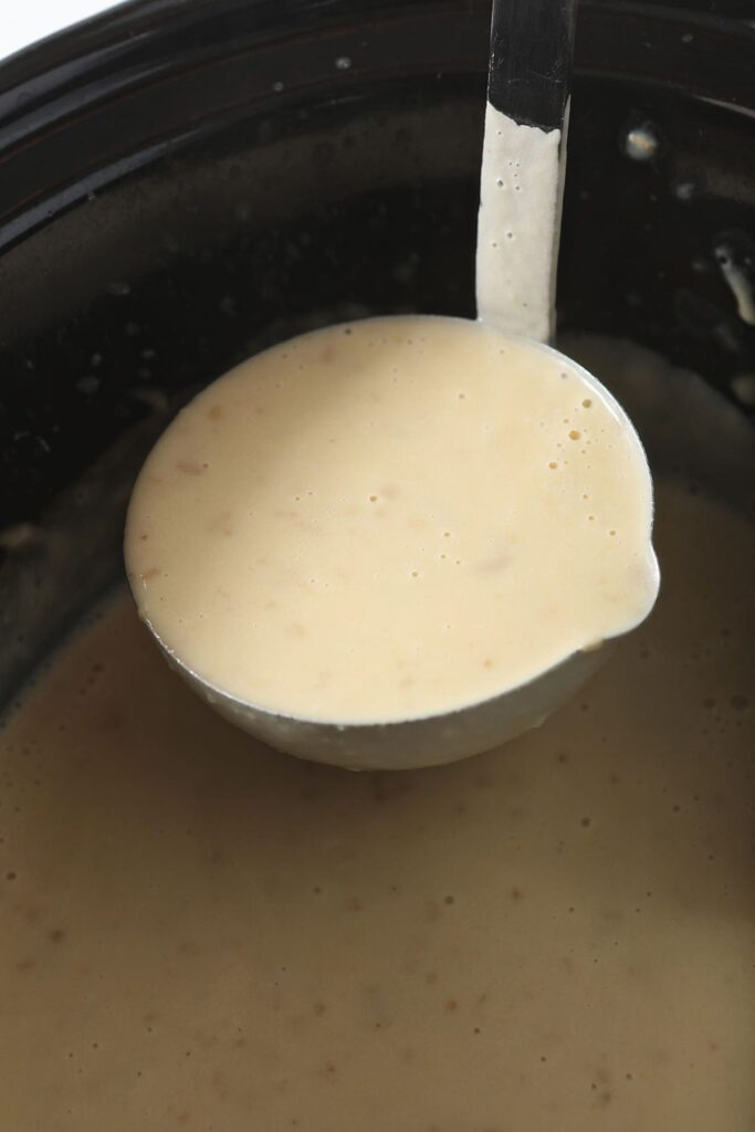 A ladle holds a serving of Creamy Potato Soup