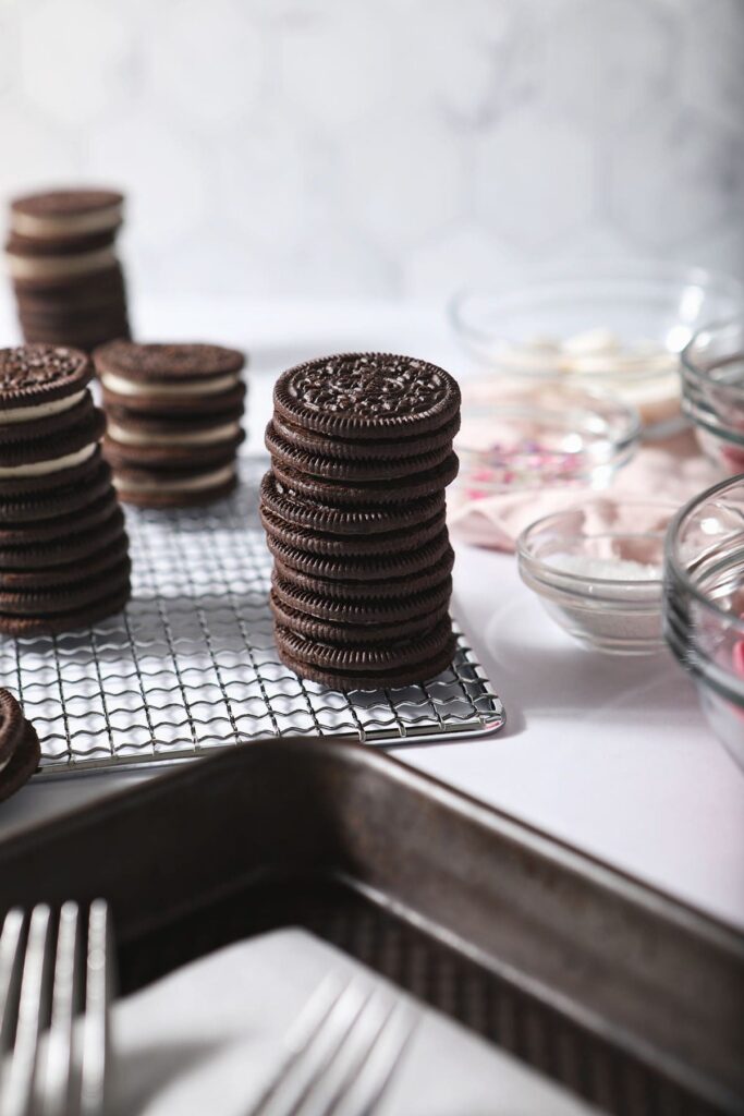 Oreos stacked next to bowls of decorations