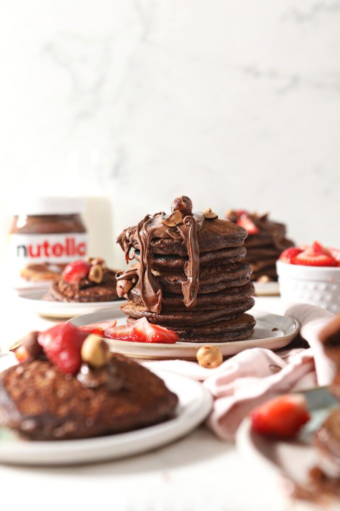 A stack of Nutella Pancakes drizzled with extra Nutella