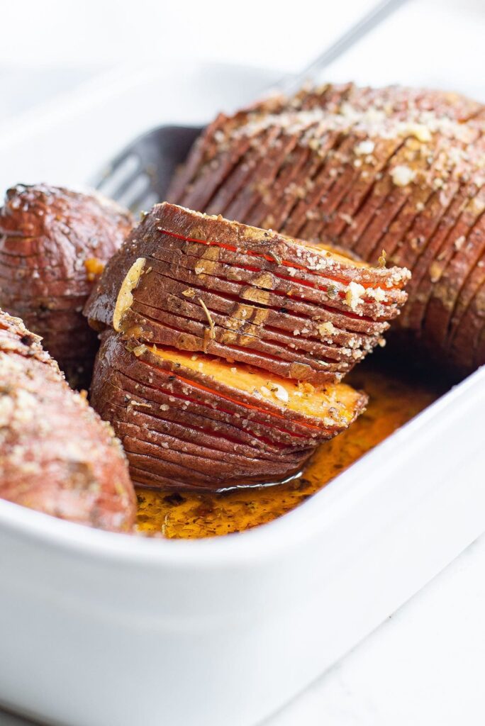 Sliced hasselback sweet potatoes in a baking dish after roasting