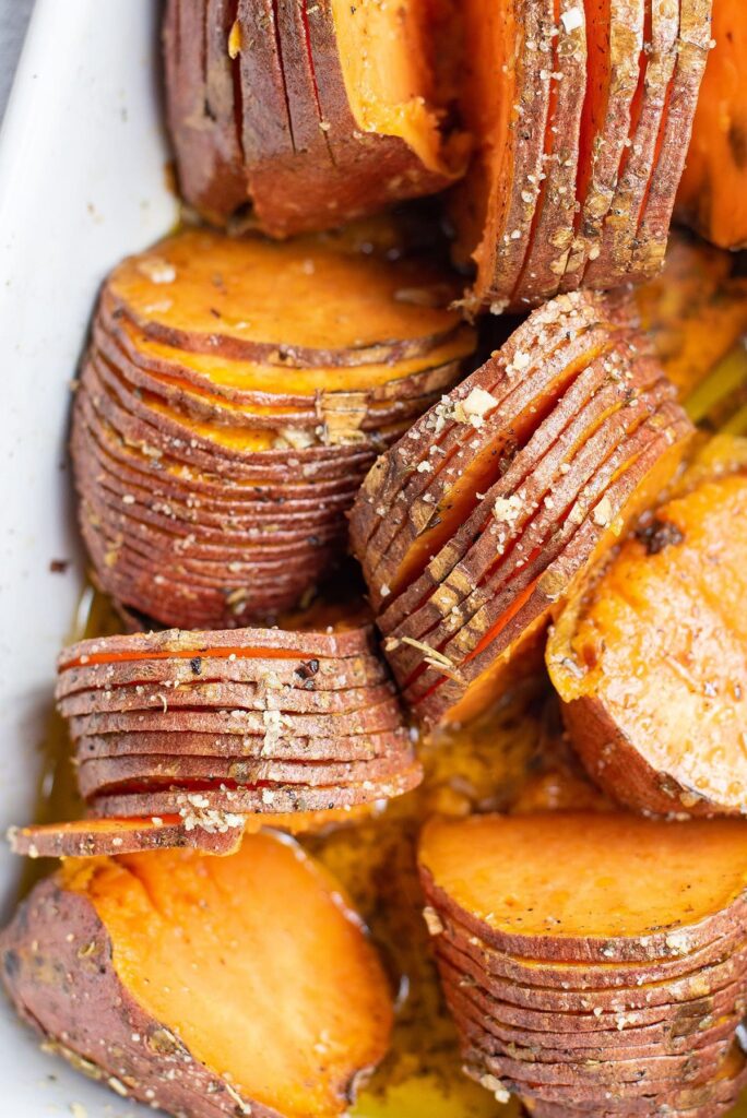 Close up of hasselback sweet potatoes after roasting in a baking dish