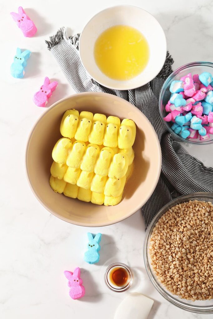 Peeps, crispy rice cereal and other ingredients in bowls on marble