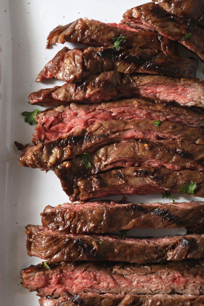 Close up of thinly sliced skirt steak on a white plate