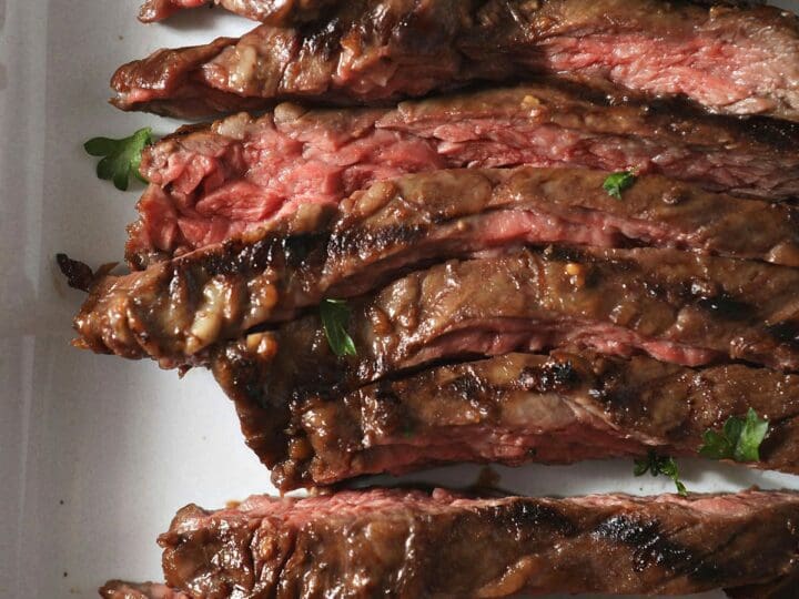 Close up of thinly sliced skirt steak on a white plate