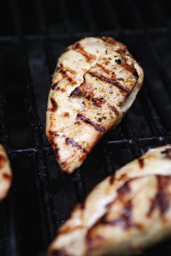 A chicken breast on a grill with grill marks