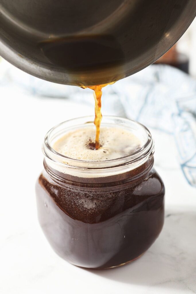 Runny honey pours into a mason jar