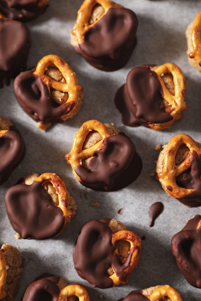 Close up of chilled Chocolate-Covered Peanut Butter Pretzels on a sheet pan