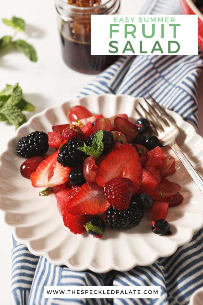 A white plate holds a serving of watermelon fruit salad with a fork on a geometric blue towel with the text easy summer fruit salad