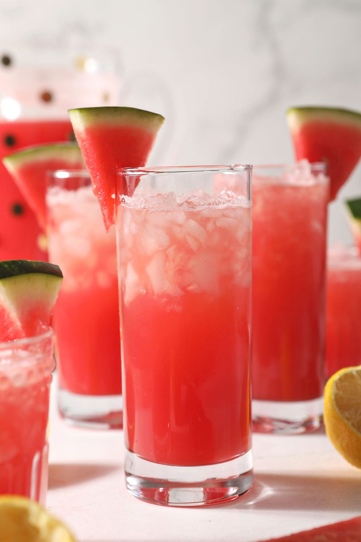 Four glasses of watermelon lemonade on marble