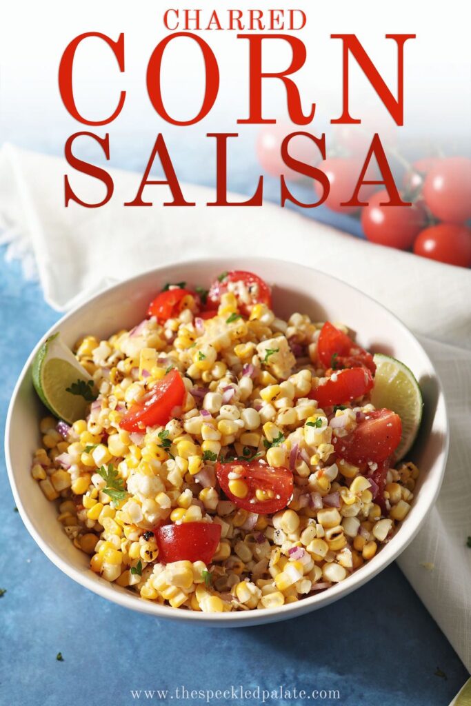 A bowl of corn, tomatoes and limes on a blue counter with the text charred corn salsa