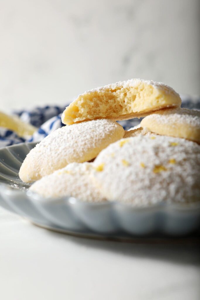 A blue plate of Lemon Cooler Cookies with one bitten into