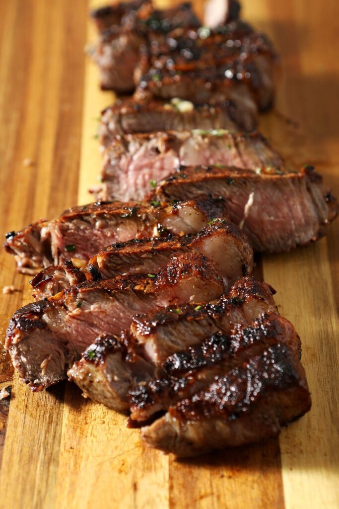 Sliced steak on a wooden cutting board