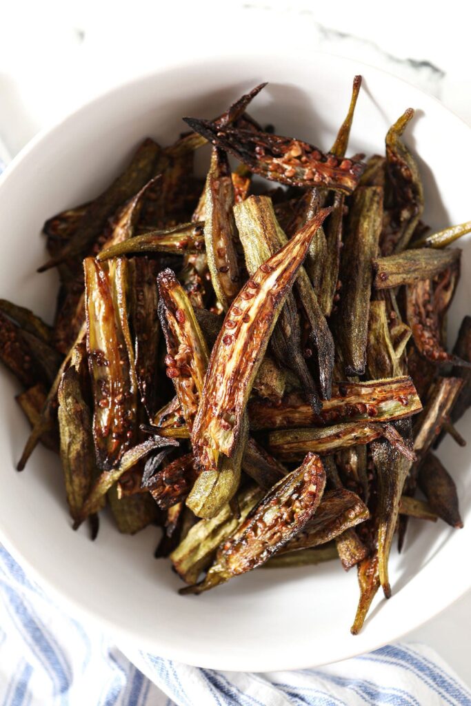 A bowl of oven roasted okra on marble