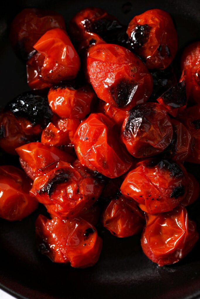 Close up of charred tomatoes in a black bowl