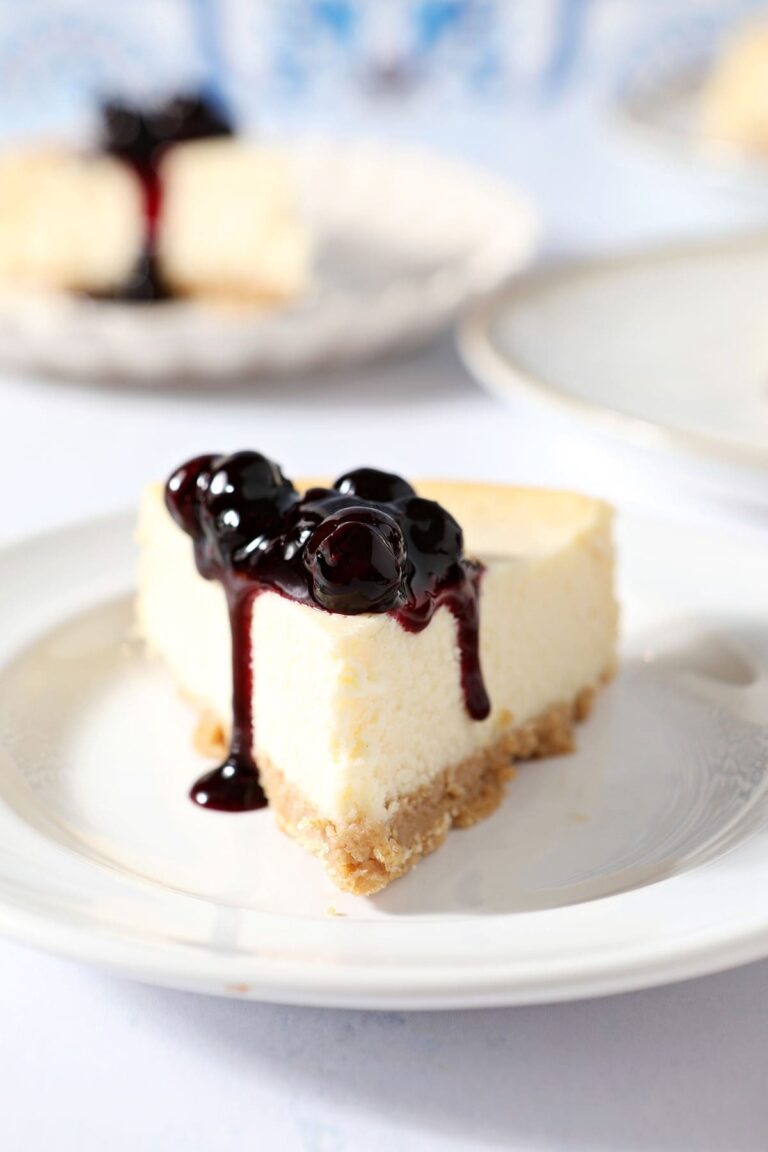 A slice of cheesecake topped with blueberry sauce