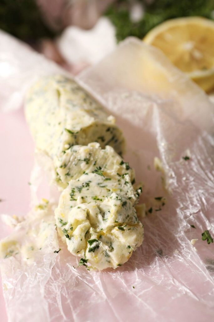 Slices of garlic herb butter on wax paper