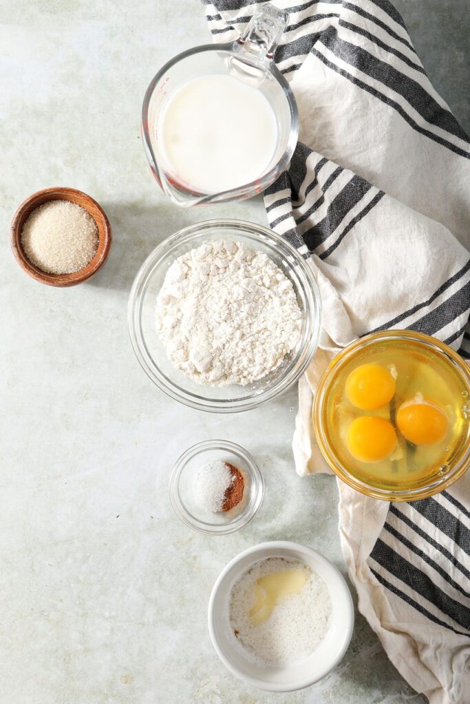 Ingredients to make a German pancake in bowls on a green countertop