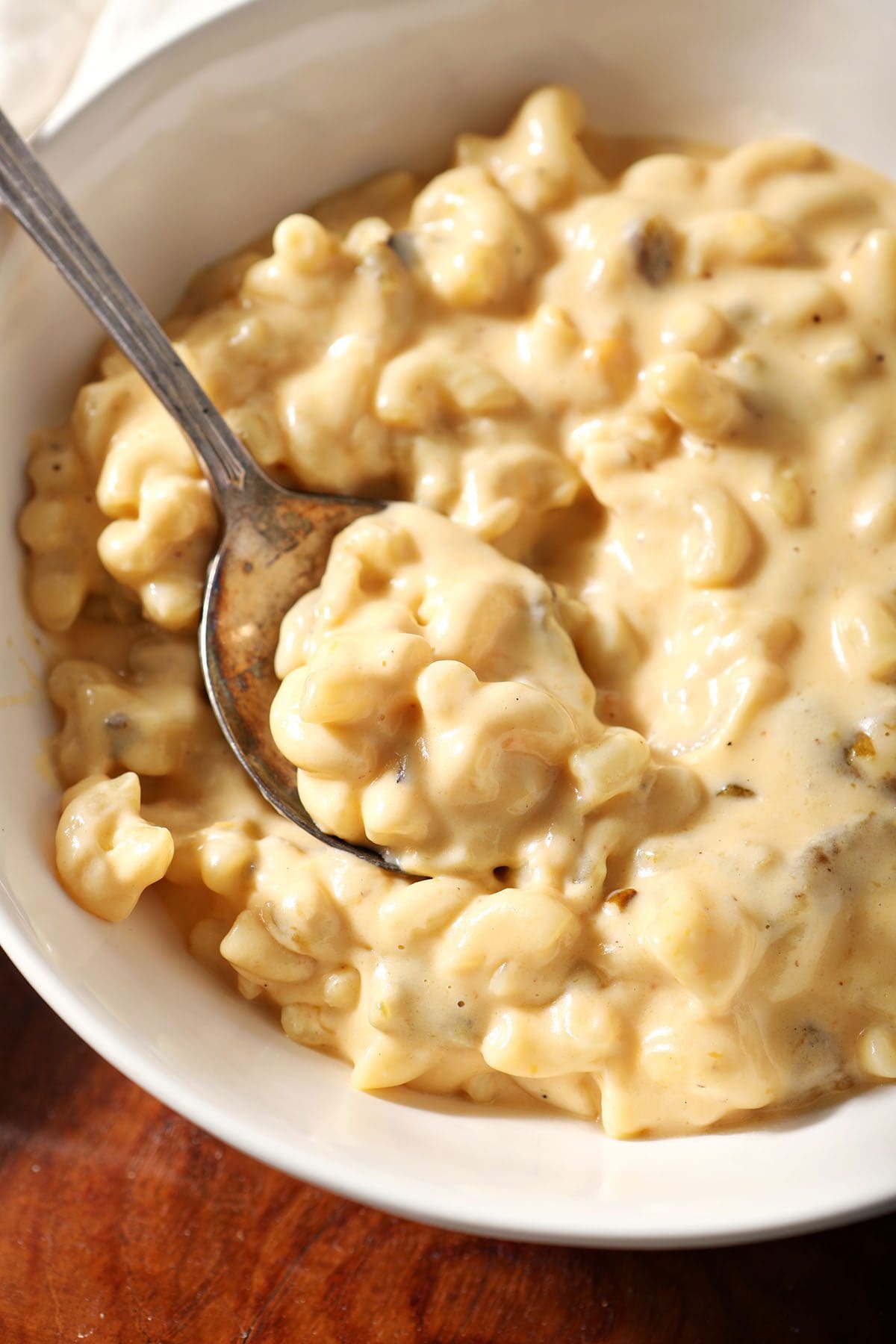 A spoon sits in a bowl of Hatch Chile pepper Mac n cheese