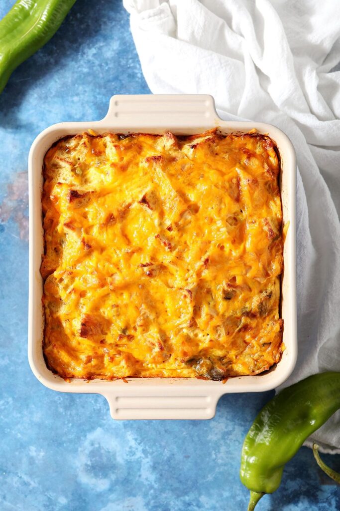 A baked egg casserole on a blue background with green peppers