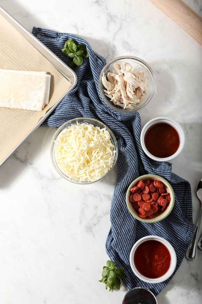 Ingredients to make easy pizza on a blue towel with marble