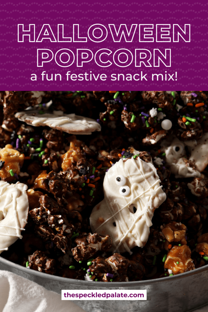 Close up of a bowl of chocolate, caramel and white chocolate popcorn mix with the text Halloween popcorn a festive snack mix