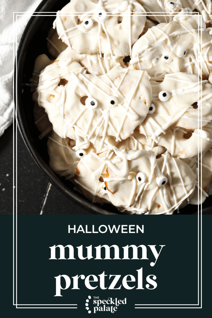 A bowl of pretzels decorated like mummies with eyes with the text halloween mummy pretzels