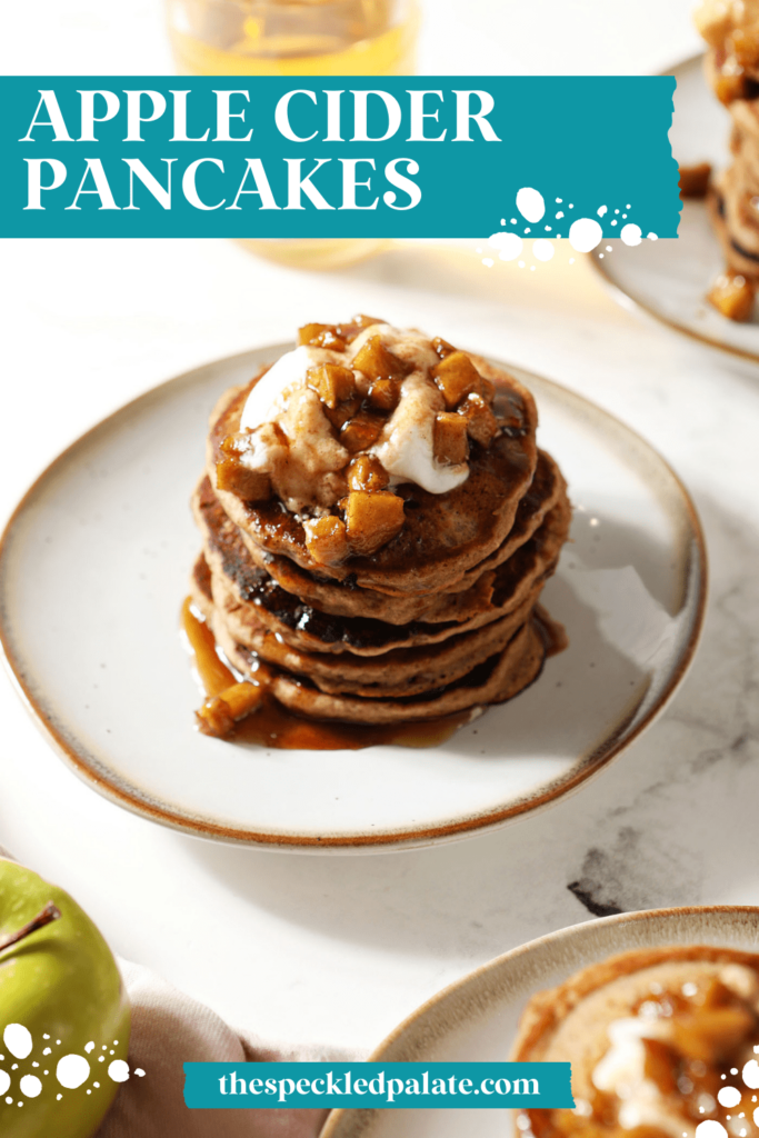 A stack of Apple Pancakes on a plate garnished with whipped cream and caramelized apples with the text apple cider pancakes