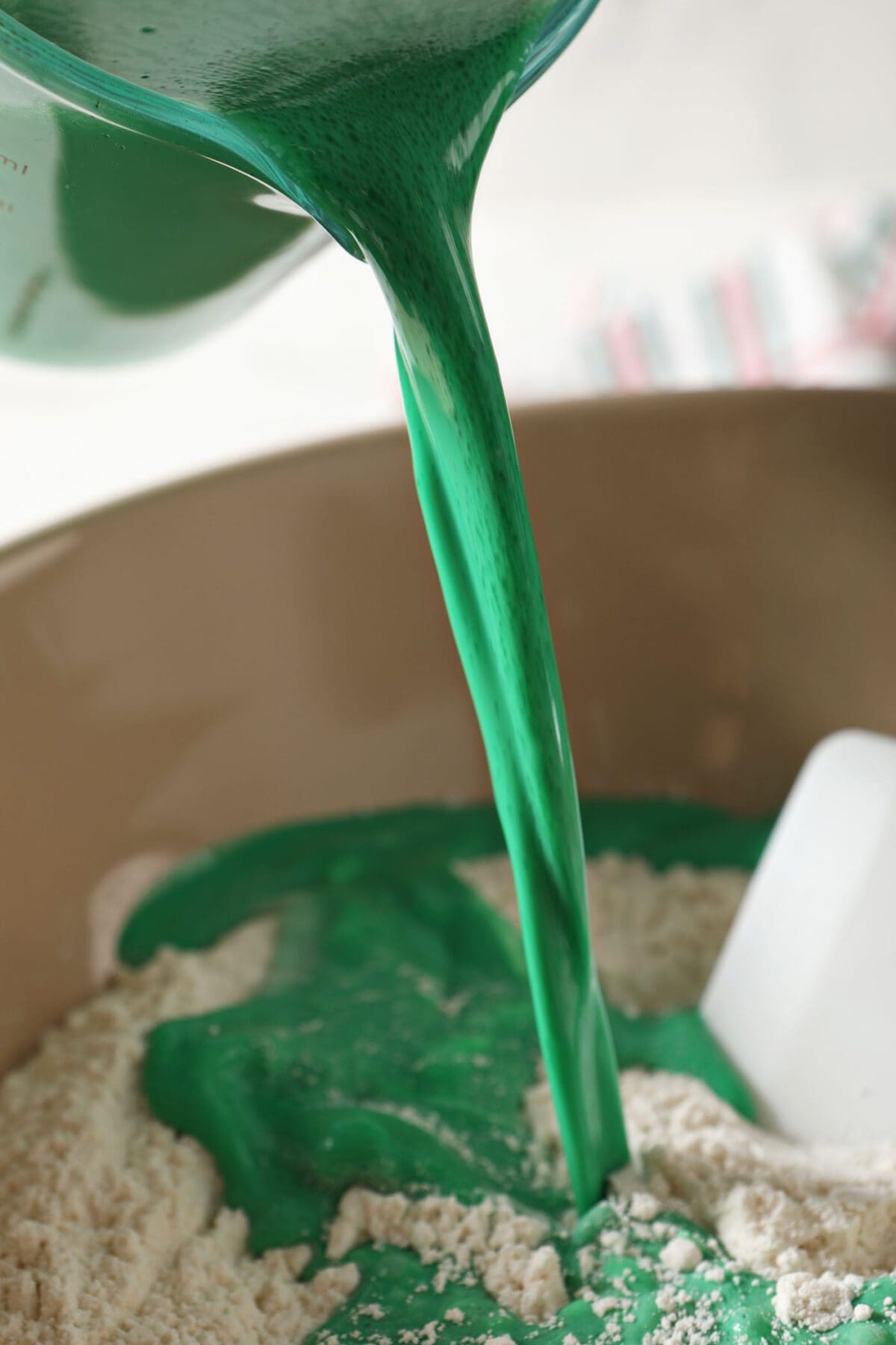 Green liquid pours into the dry ingredients to make Christmas pancakes