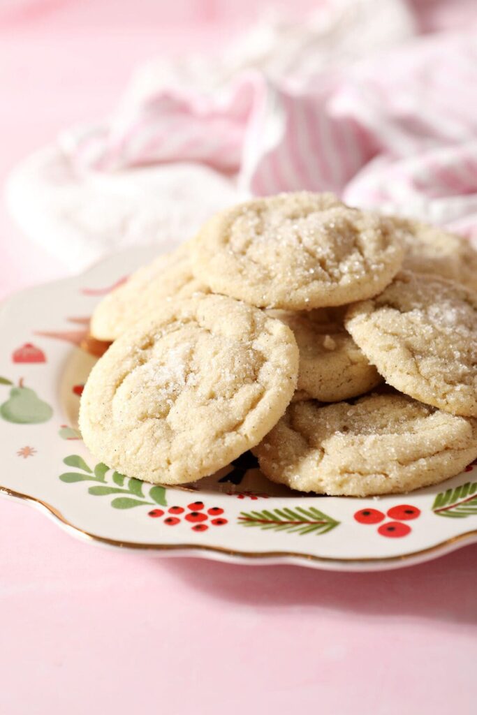 A Christmas platter of Drop Sugar Cookies on a pink countertop