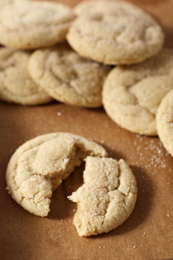 A halved drop sugar cookie on parchment with other cookies