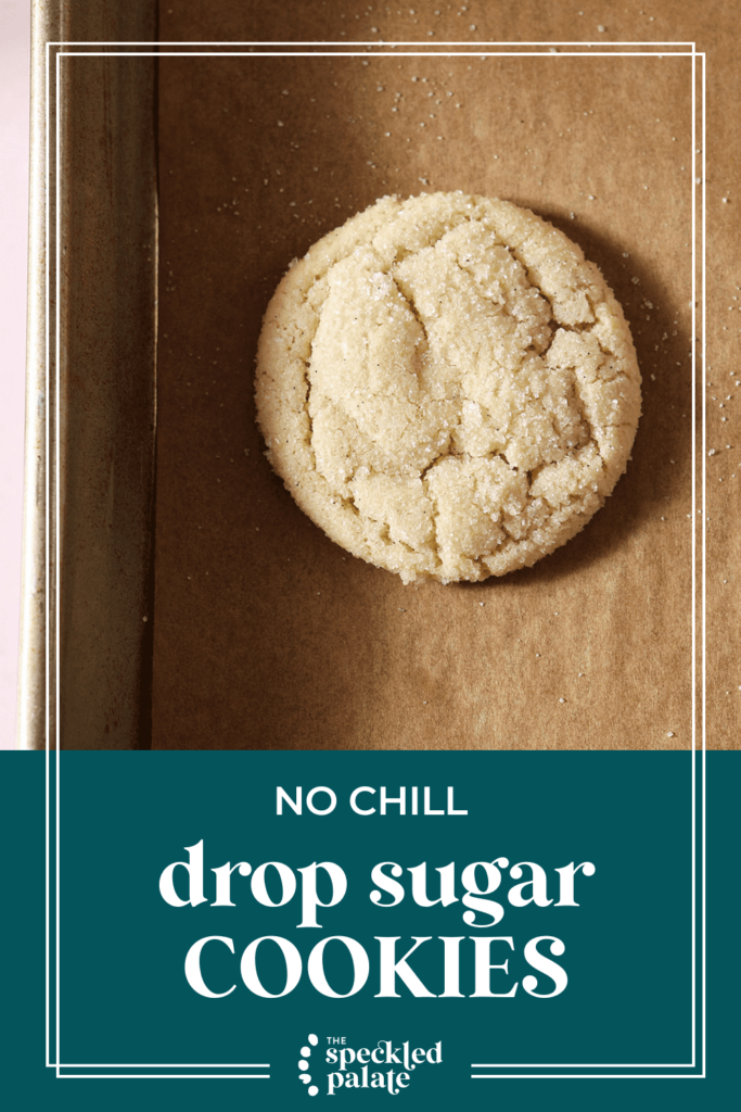 A round cookie on parchment on a sheet pan with the text No Chill Drop Sugar Cookies