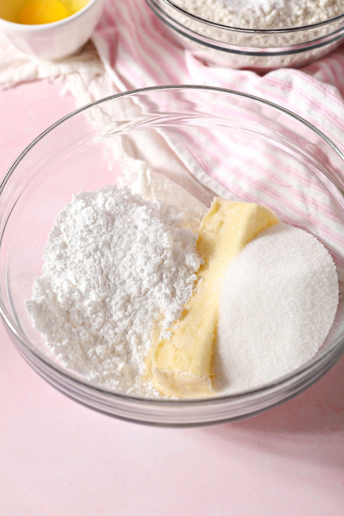 Butter and sugars in a bowl on a pink countertop