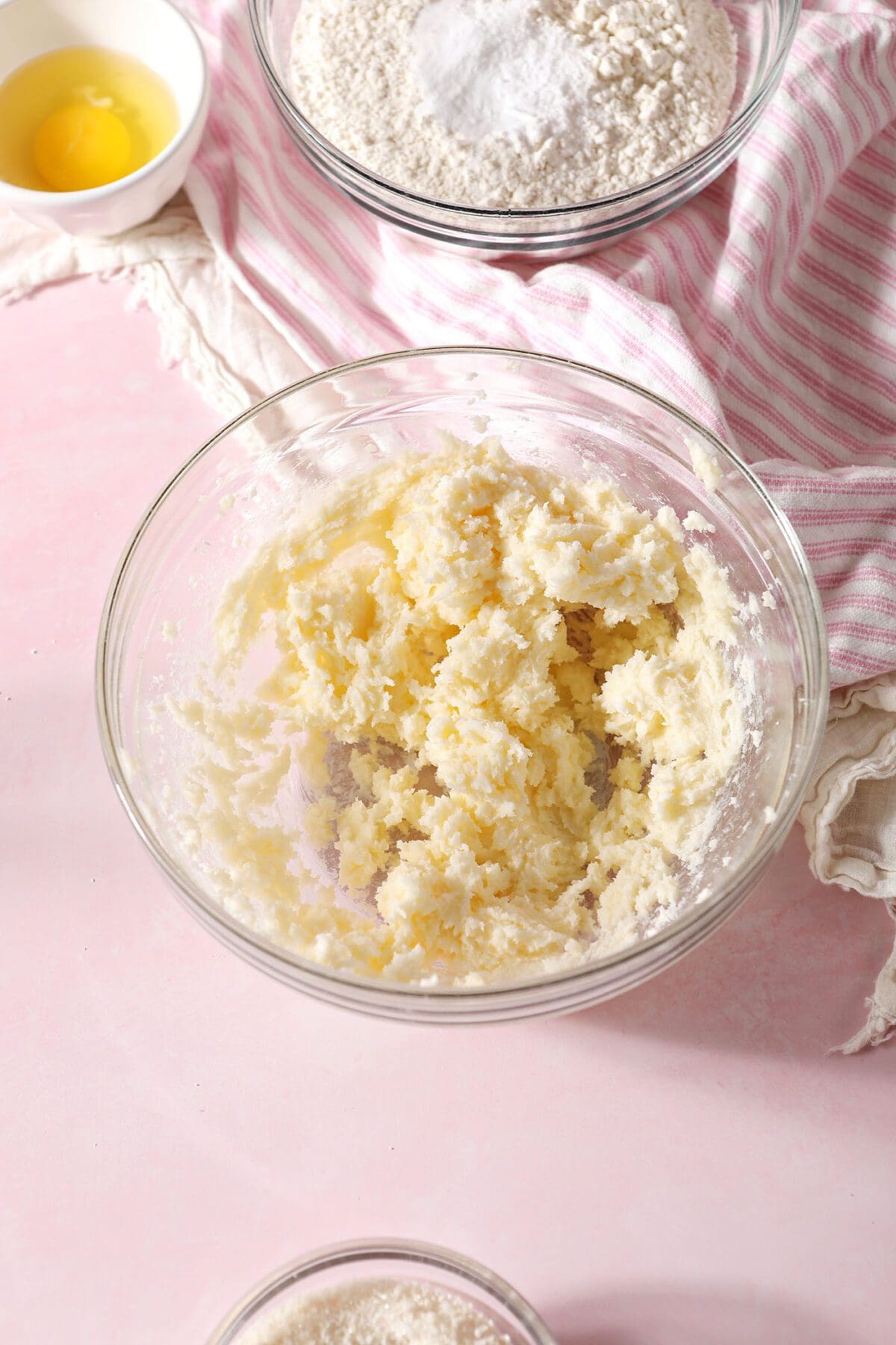 Creamed butter and sugars in a bowl surrounded by other ingredients