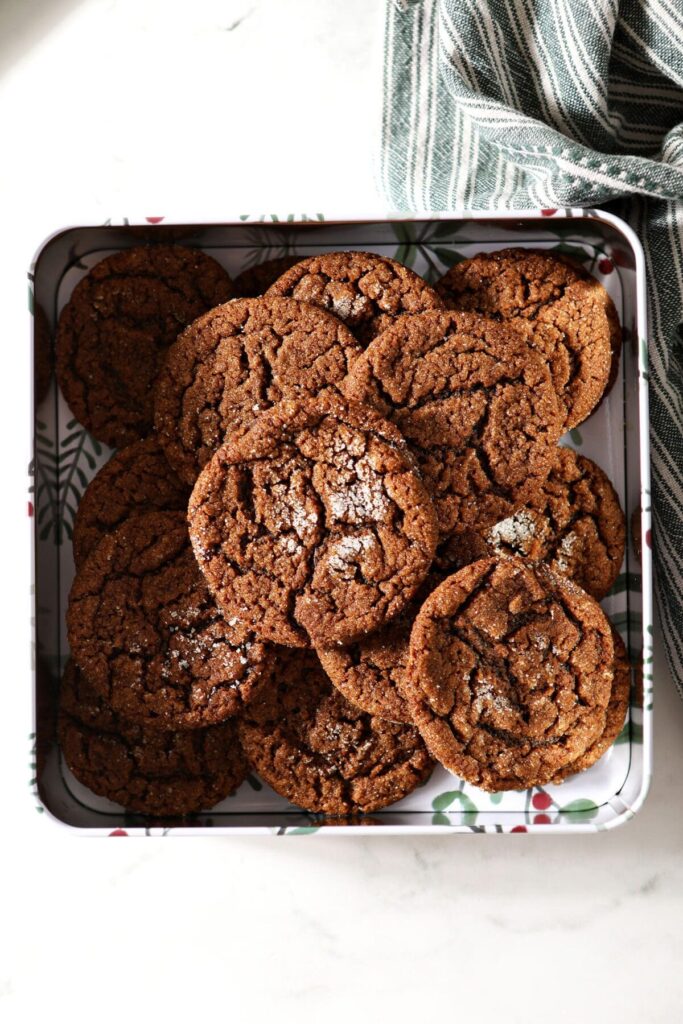 Sugar-coated gingersnap cookies in a cookie tin on marble