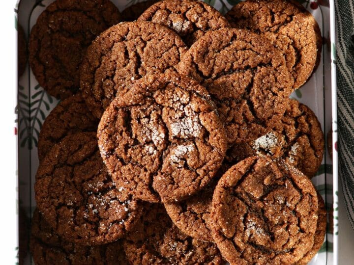 Sugar-coated gingersnap cookies in a cookie tin on marble