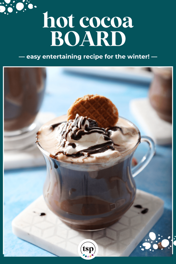 Close up of a mug of hot chocolate topped with a cookie, whipped cream and a drizzle of chocolate with the text hot cocoa board easy entertaining recipe for the winter