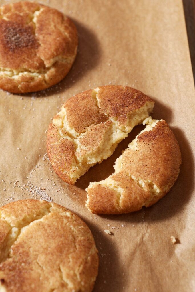 A halved snickerdoodle cookie on a baking sheet