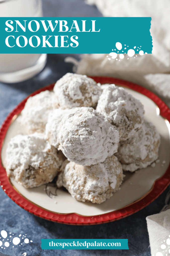 A red-rimmed plate of sugar-covered cookies on a blue countertop with the text snowball cookies