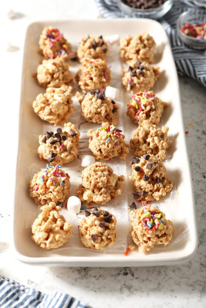 Avalanche cookies topped with various toppings on a white platter