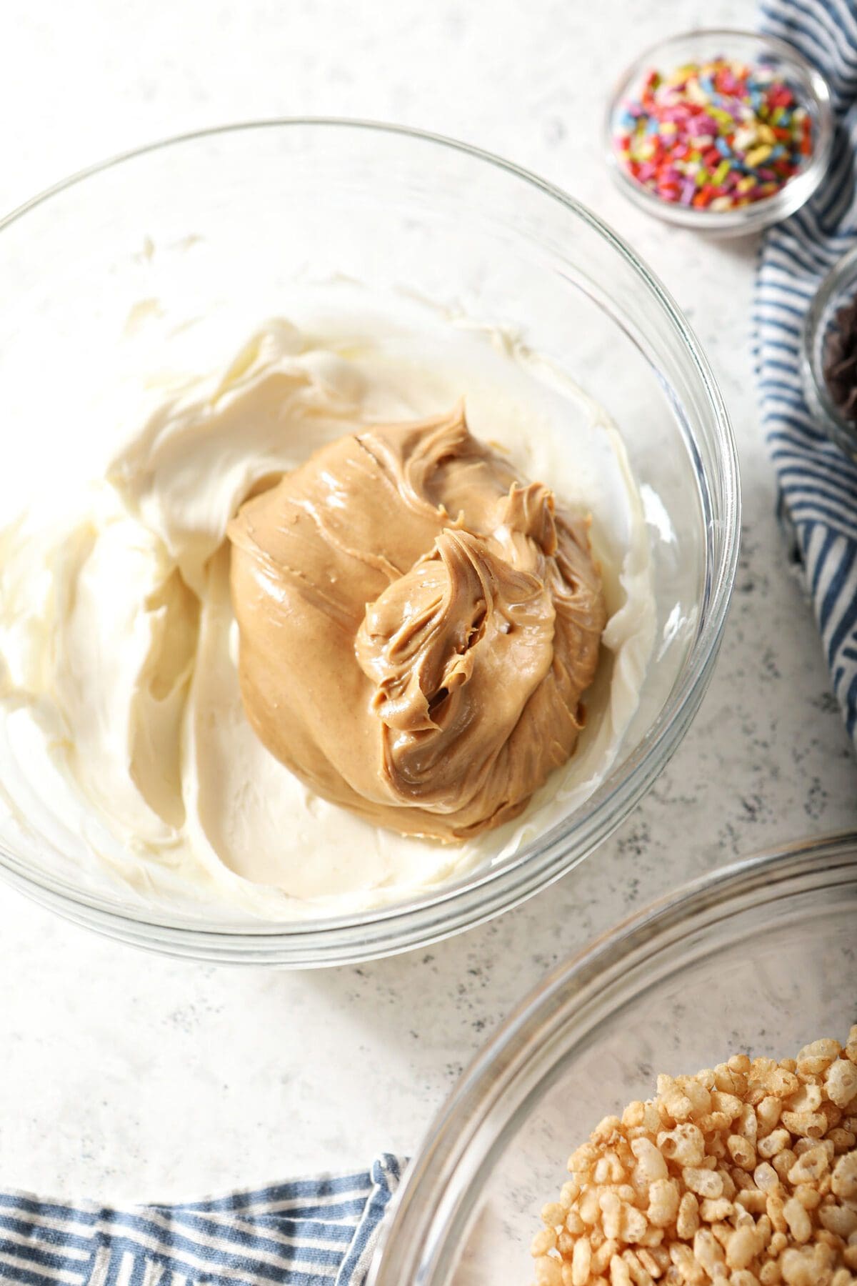 Peanut butter sits on top of melted white chocolate in a large bowl