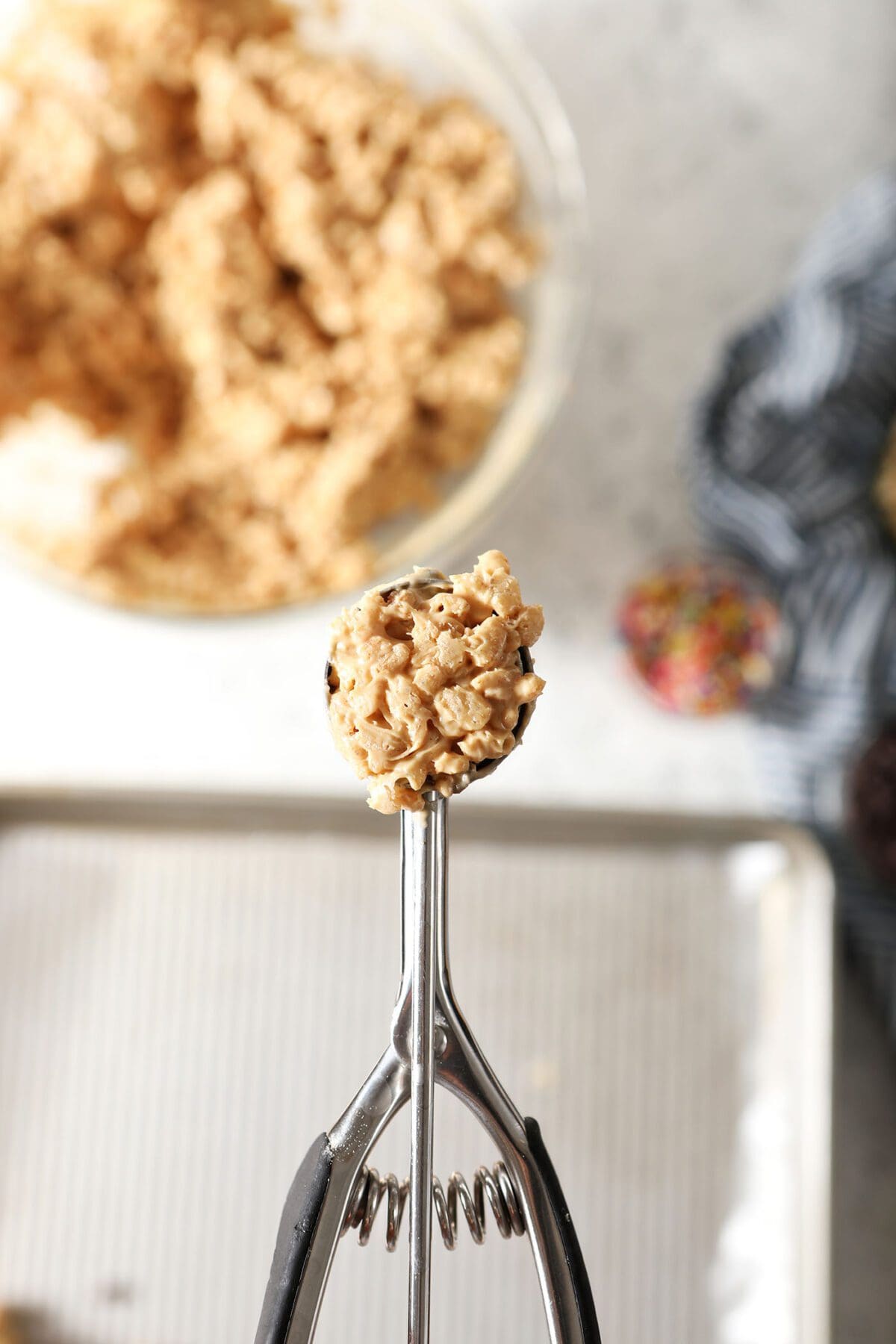 A cookie scoop holds a scoop of avalanche cookie batter