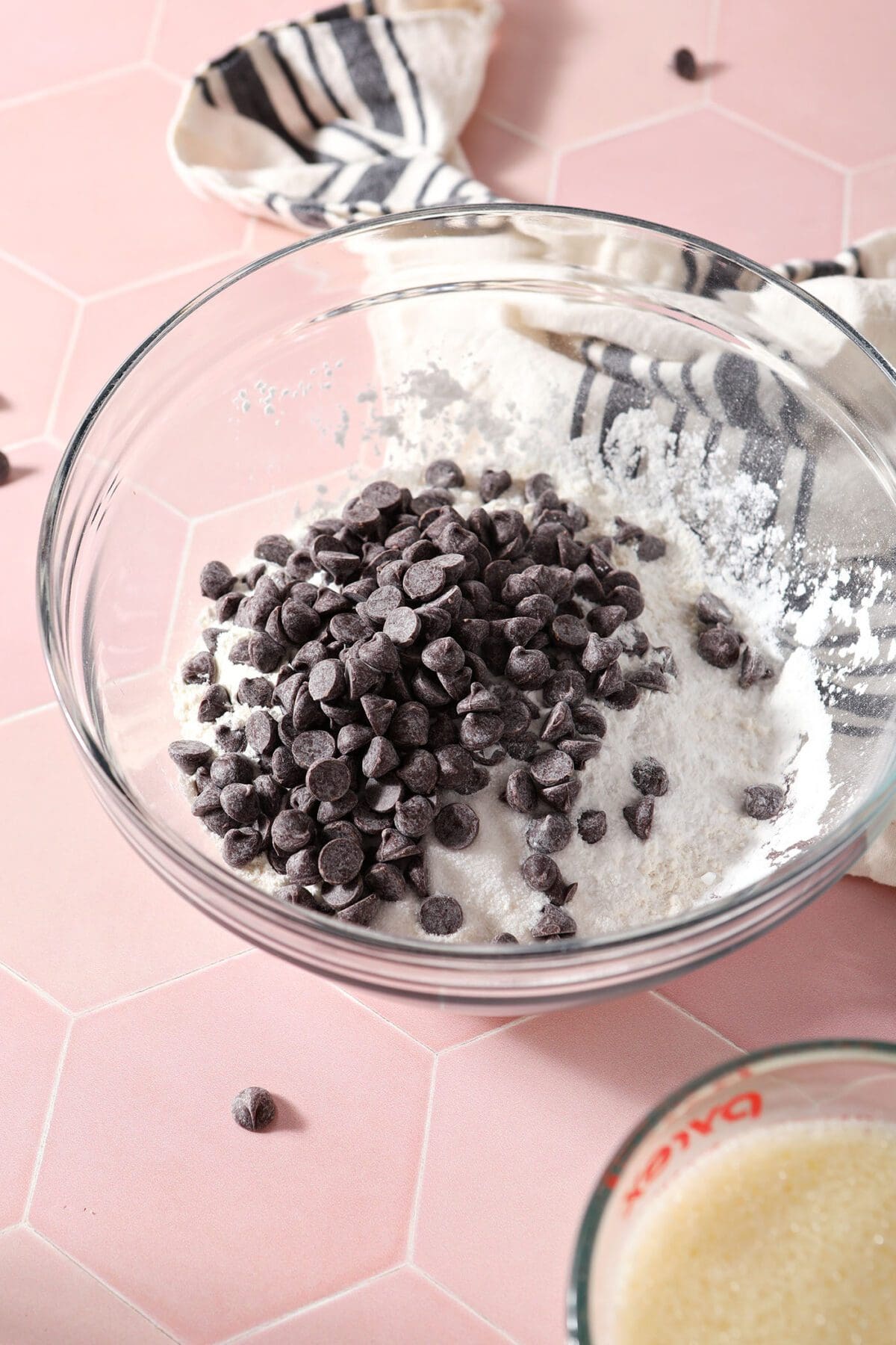 Dry ingredients in a bowl before mixing on a pink tile countertop