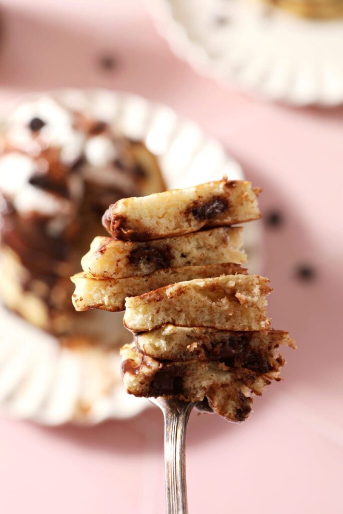 A fork holds a large bite of Chocolate Chip Pancakes