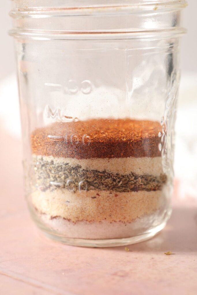 Spices and herbs layered in a mason jar to make a seasoning blend