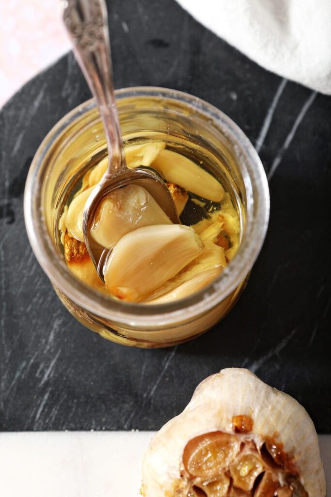 Roast garlic cloves in a jar with oil and a spoon