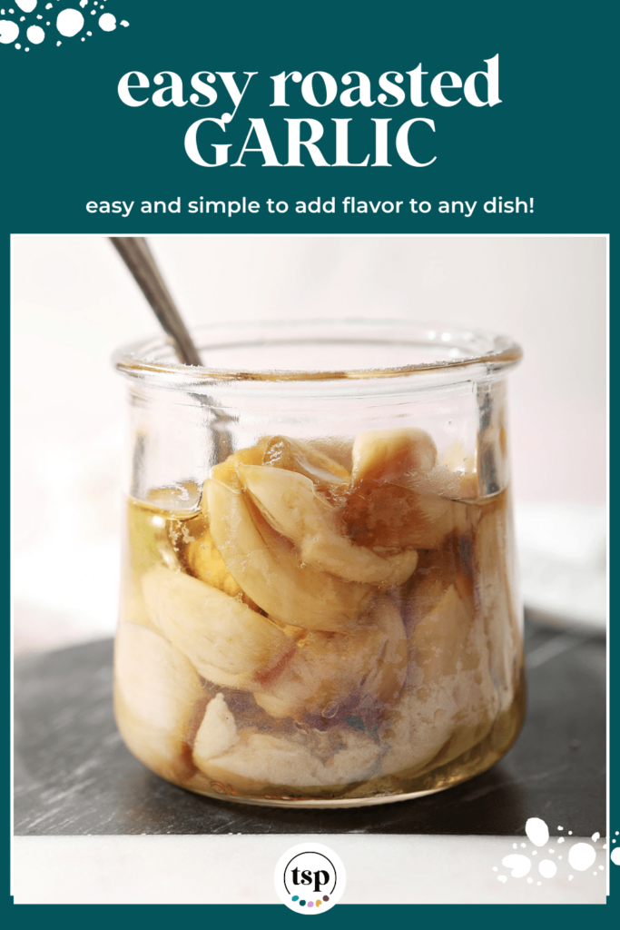 A jar of roasted garlic cloves with a spoon inside sits on black and white cutting board with the text easy roasted garlic easy and simple to add flavor to any dish