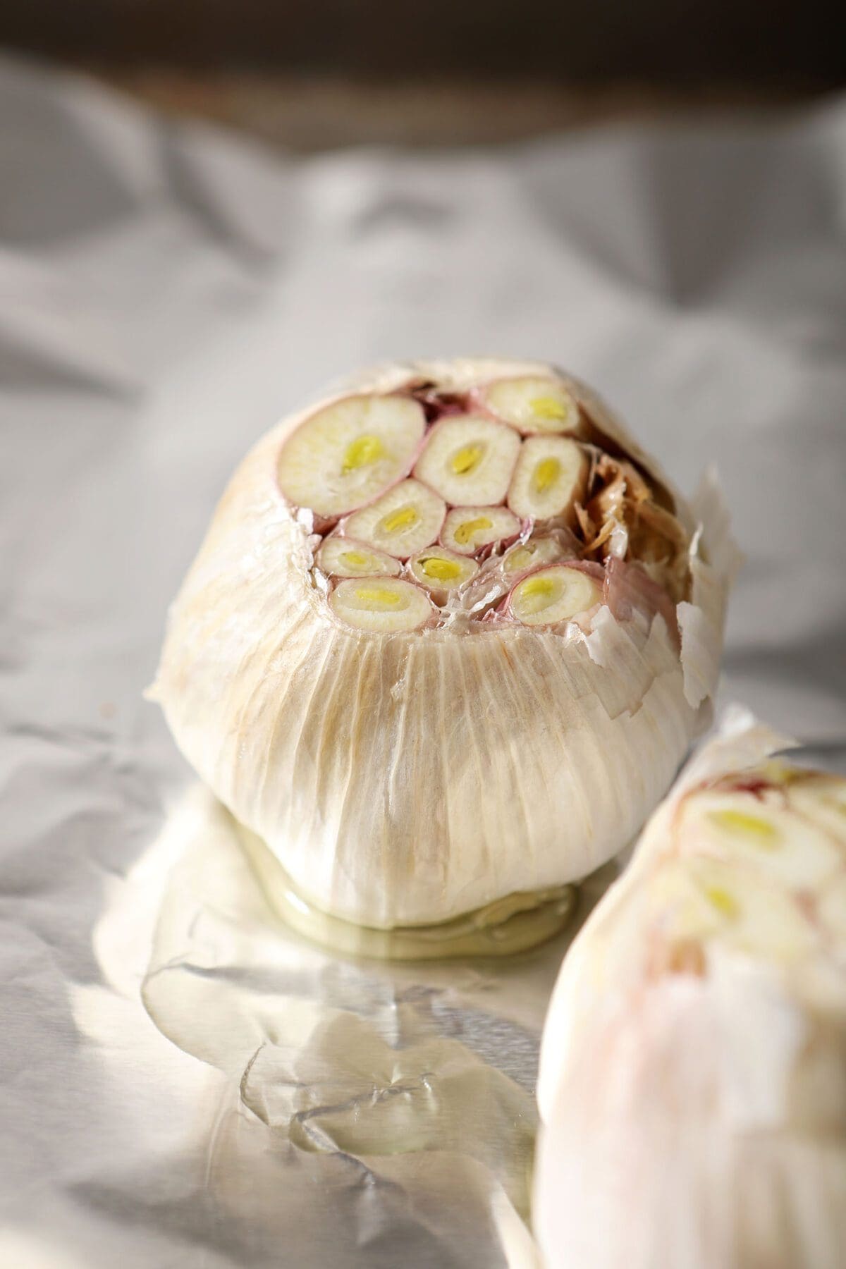 Close up of a raw head of garlic with oil on it before roasting